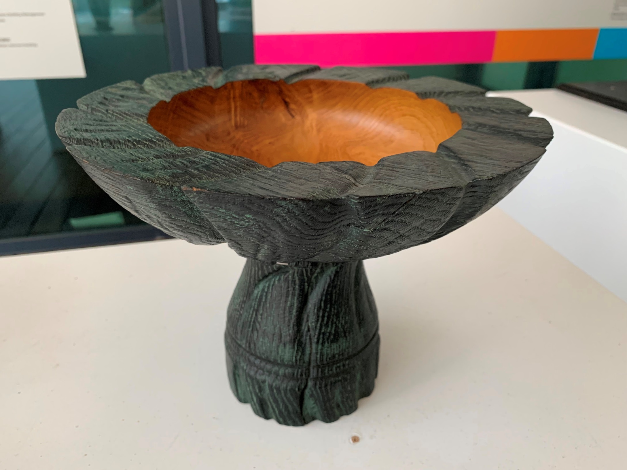 【Pedestal Bowl】Irish white oak is difficult to dry without splitting or checking. To present a natural finish, the artist carved petals on the pedestal to match the flower-shaped bowl. The shallowness of the bowl makes it hard to look inside, giving the impression of a noble inner beauty. by: Joe LAIRD, Wood Turner, Ireland